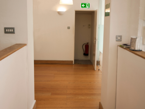 Fire exit in office building, marked with emergency lighting